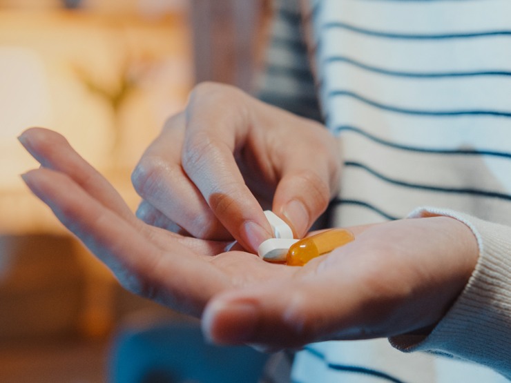 image of a hand holding several supplements