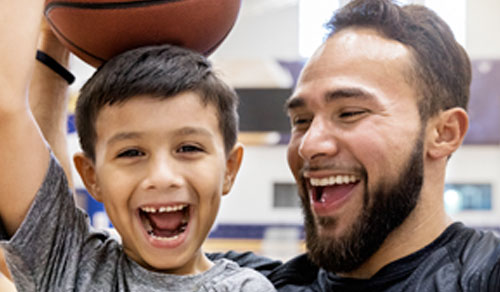 Father and child posing with a basketball