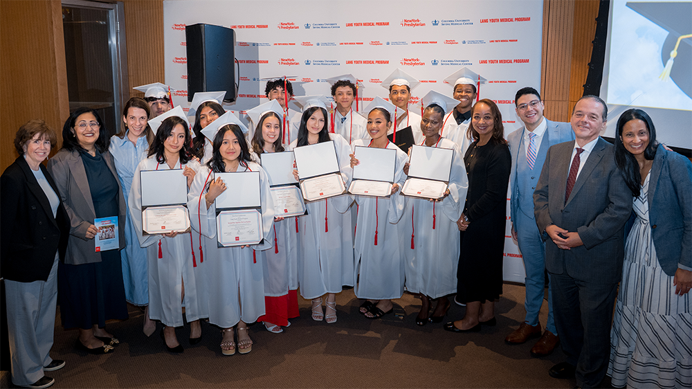 Group of people and children in graduation costumes.