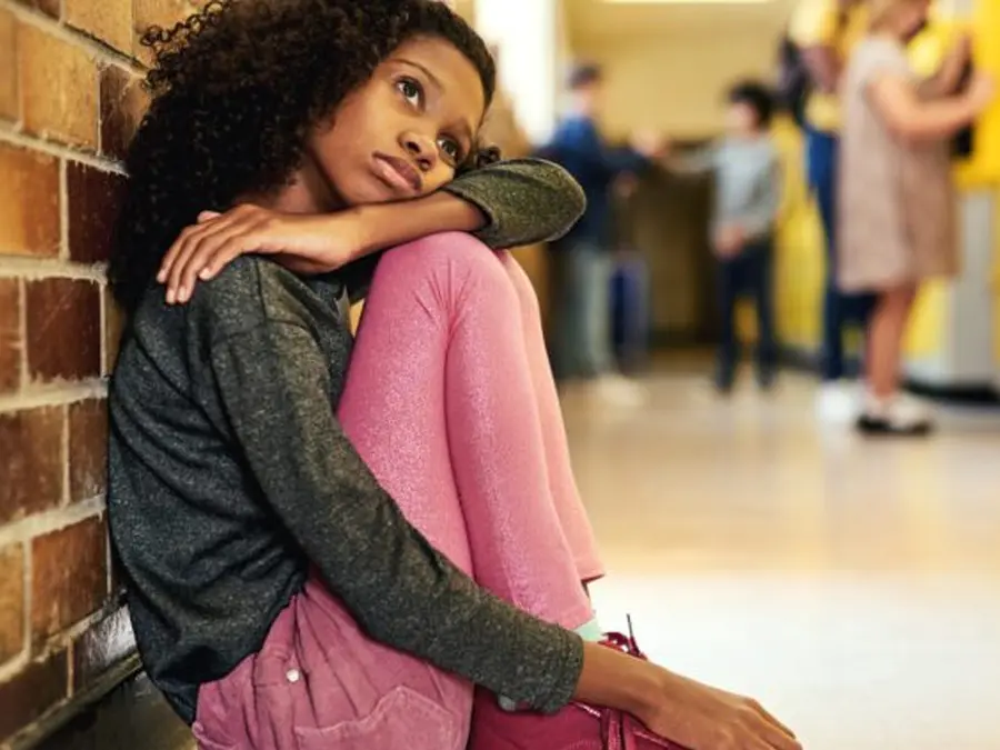 Girl in school hallway who looks sad after bullying