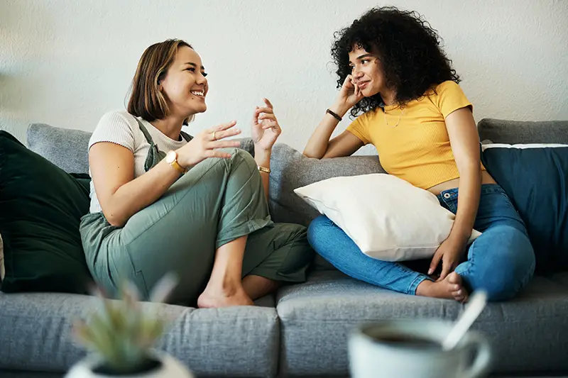 image of two girls talking to each other on the couch